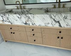 a bathroom vanity with marble top and drawers