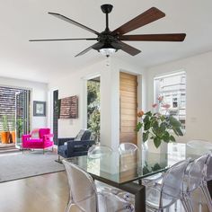 a dining room table with chairs and a ceiling fan in the middle of the room