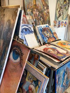 many paintings are on display in an art studio, with one being opened to reveal the viewer's eye