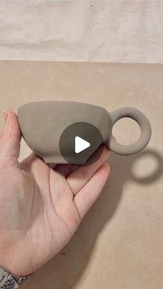 a hand holding an object that looks like it is made out of clay