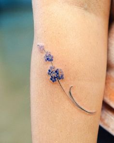 a small blue flower tattoo on the leg