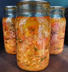 three jars filled with food sitting on top of a table