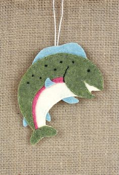 a green ornament with a fish on it's back hanging from a string