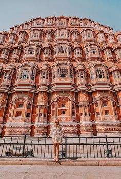 a woman standing in front of a tall building