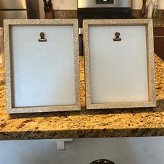 two white frames sitting on top of a counter