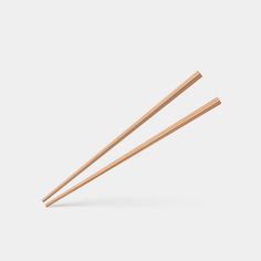 two wooden chopsticks on a white background