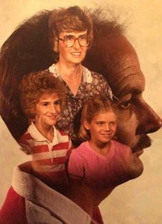 an older woman and two young children standing in front of a portrait of a man