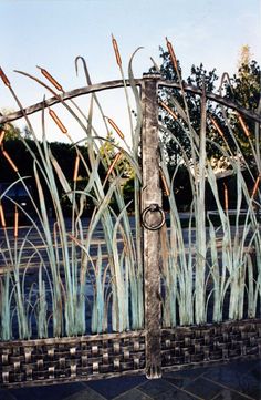 an iron gate with grass growing through it