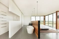 a bathroom with a tub, sink and large glass windows in it's walls