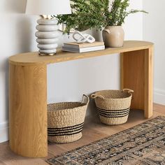 a wooden table with two baskets on top of it next to a lamp and rug