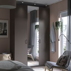 a bedroom with a bed, chair and large mirror in the wall next to it