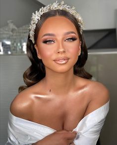 a woman wearing a tiara and dress posing for a photo with her hands on her chest