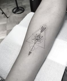 a black and white photo of a person's arm with a flower tattoo on it