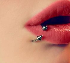 a woman's lips and nose piercings are seen in this artistic photo from the waist up