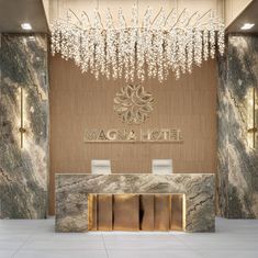 a hotel lobby with marble walls and chandelier