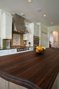 a kitchen with an island counter top next to a sink and stove in the center