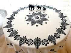 a round table with black and white designs on it, surrounded by two small figurines