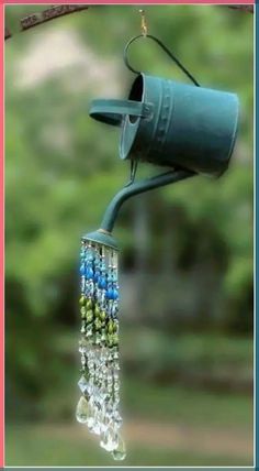 a bird feeder hanging from the side of a tree branch with beads attached to it