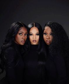 three black women with long hair posing for the camera in front of a dark background