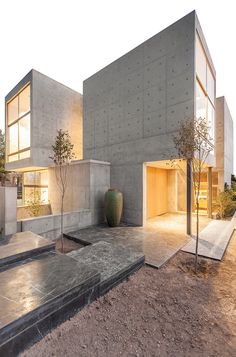 a concrete building with steps leading up to it and a vase in the foreground