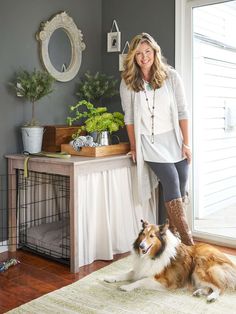 a woman standing next to a brown and white dog