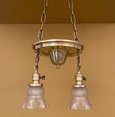 two light fixtures hanging from a ceiling fixture