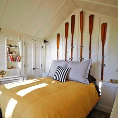 a bed with yellow sheets and pillows in a room