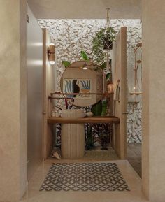 an entry way with a mirror and potted plants