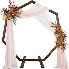 a wedding arch decorated with flowers and fabric