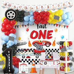 a birthday party with balloons, cars and race themed decorations on the wall above it