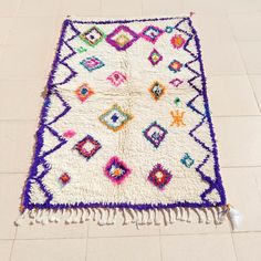 a multicolored rug on the floor with tassels