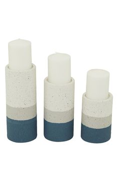 three white and blue candles sitting in front of each other