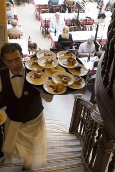 a waiter carrying plates of food down the stairs