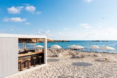 an outdoor bar on the beach with umbrellas