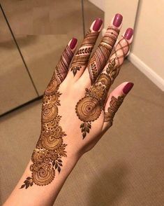 a woman's hand with henna tattoos on it