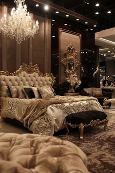 a luxurious bedroom with chandelier, bed and mirror in the background at night