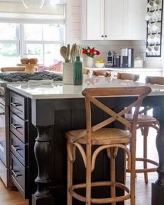 a kitchen island with two stools next to it