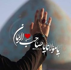 a woman holding her hand up to the sky with arabic writing on it and an image of