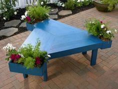 a blue table with flowers in it on a brick patio