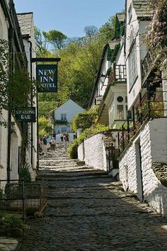 a cobblestone street lined with white buildings