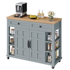 a gray kitchen island with two shelves and a microwave on the top, next to a silver toaster oven