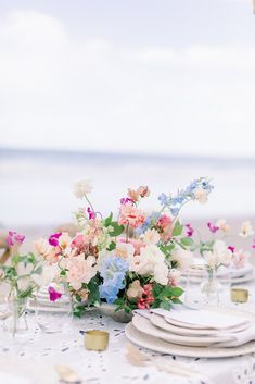 the table is set with flowers and plates