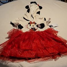 there is a red dress on the bed with minnie mouse and mickey mouse hoodie