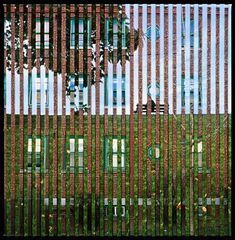 the building is made out of metal bars and has green shutters on each side