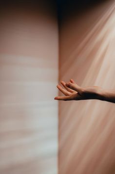 a person's hand reaching out to touch the wall