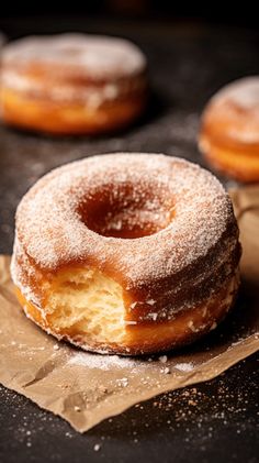 two donuts sitting on top of a piece of wax paper