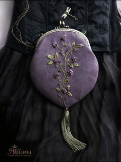 a woman wearing a purple purse with flowers on it