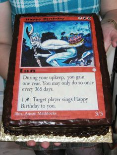 a woman holding a birthday card cake with chocolate frosting and icing on it