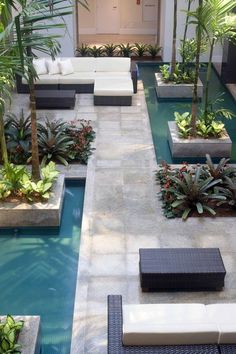 an outdoor living area with couches and plants