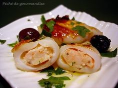 some food is on a white plate with green garnishes and olives